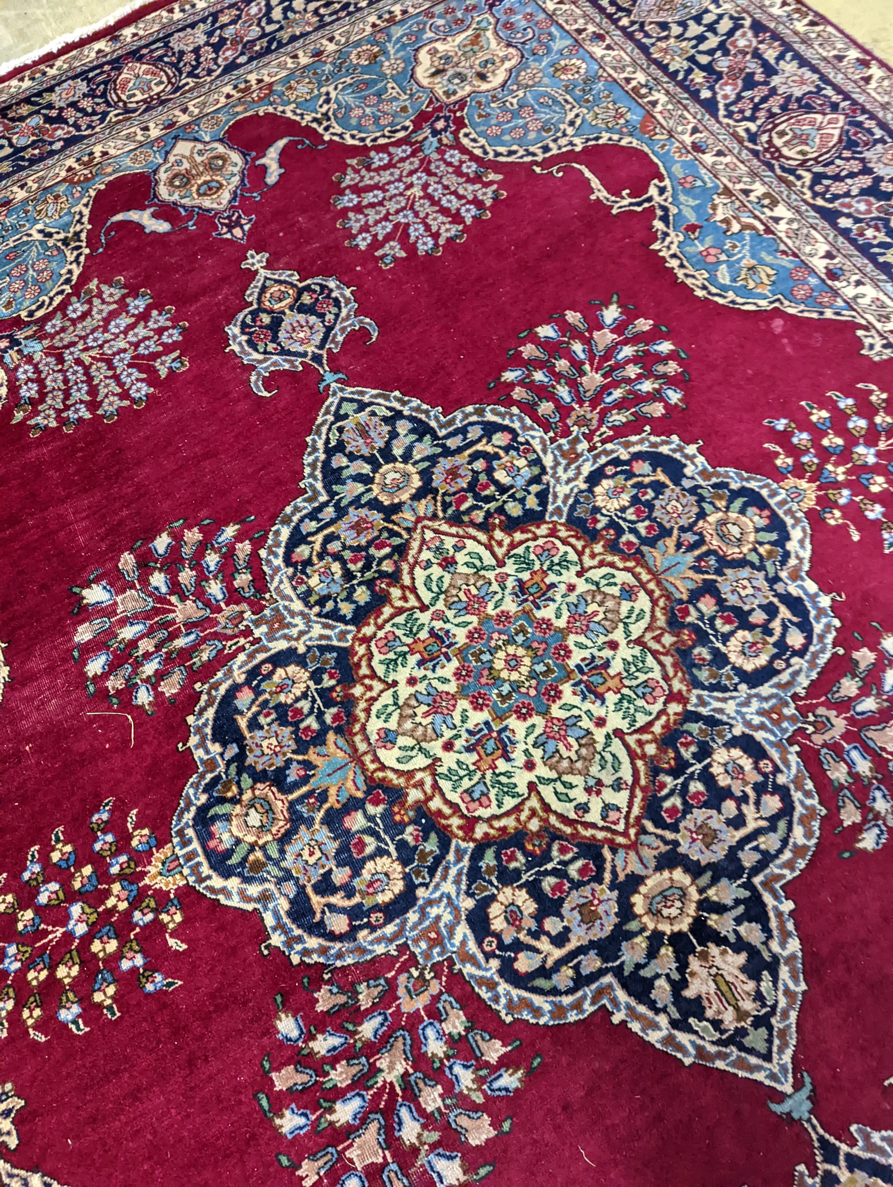 A Tabriz burgundy ground carpet, 350 x 240cm